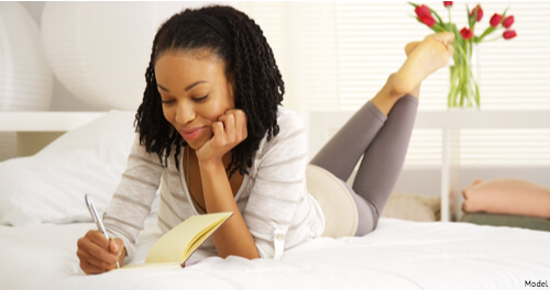 Woman laying on her stomach reading 