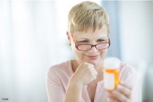 Mature woman reading the information on a pill bottle