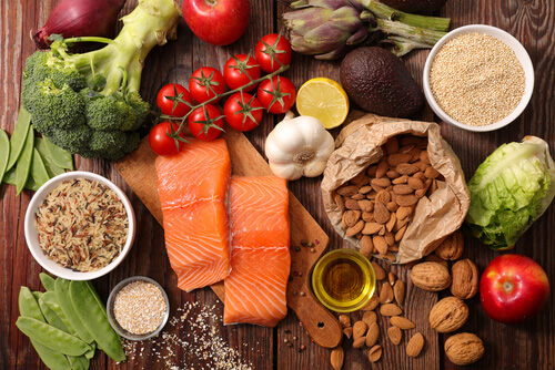 fresh food like salmon nuts and berries laid out on a table