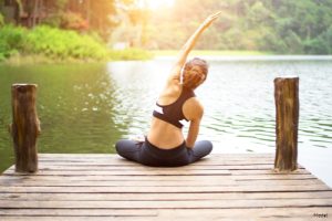 Woman sitting on a pier stretching